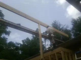 Carpenter setting a ridge beam over a new addition frame — Ice Dam Removal by Roofing Brothers in Pylesville