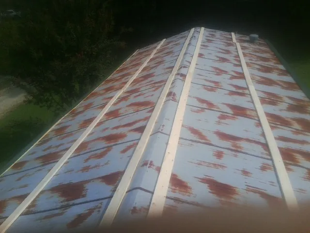 Rusted metal roof panels with new wood purlins before replacement — Storm Damage Roof Repair in Pylesville by Roofing Brothers